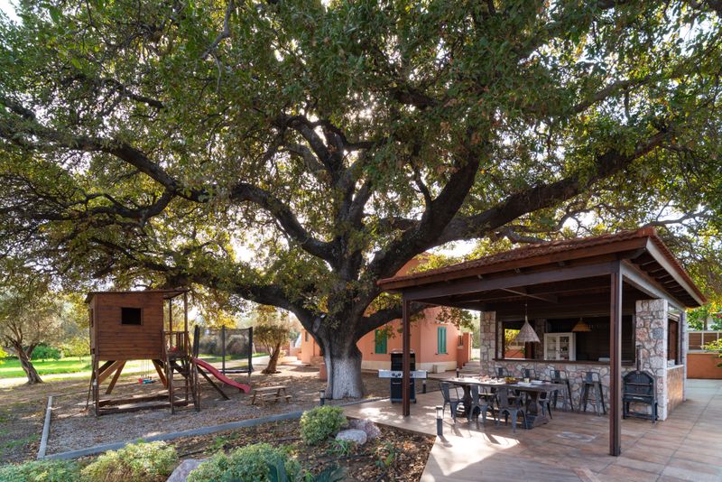 Outdoor kitchen and children's playground under the oak tree at Villa Irianna, Rhodes
