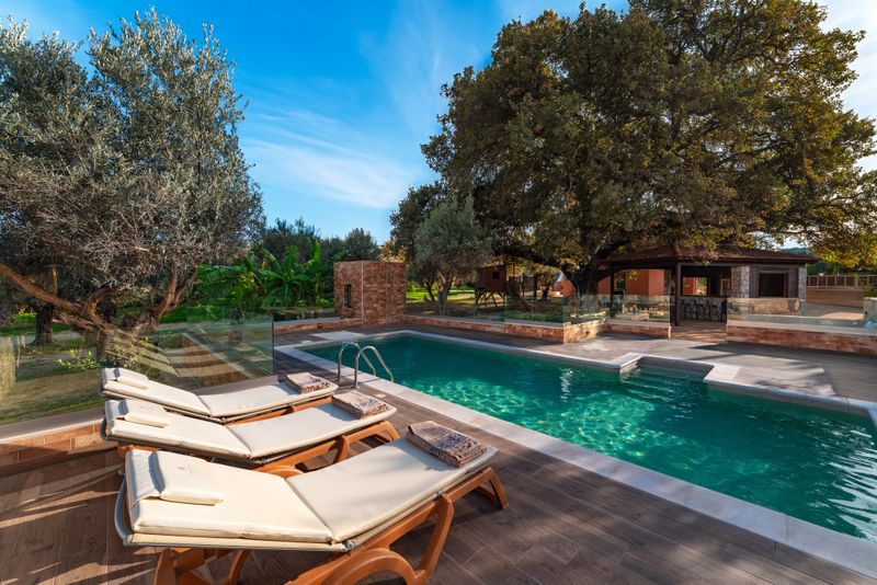 Private pool with wooden deck next to the old oak tree at Villa Irianna in Ialysos, Rhodes